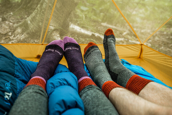 Two pairs of feet both wearing darn tough twisted yarn socks