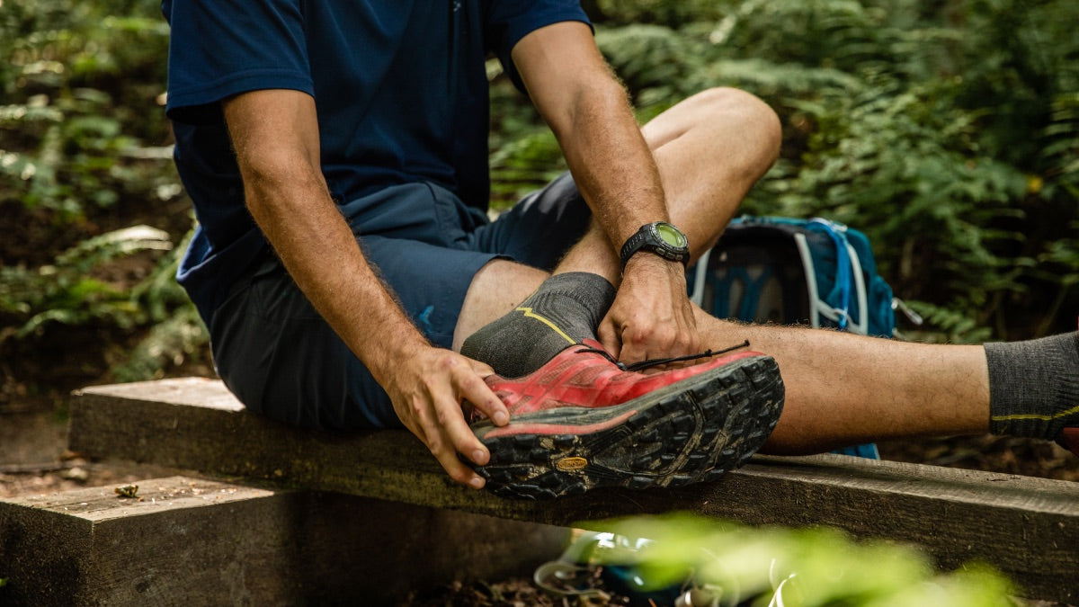 Hiker about to pull off his shoes, cause his socks aren't smelly