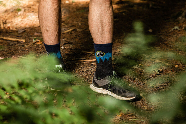 Hiker's feet wearing trail runners and the ATC hiking sock for thru hikers