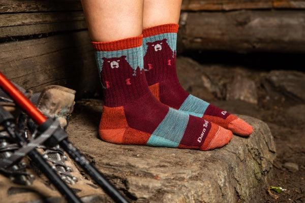 Hiker's feet wearing the adorable Bear Town hiking socks in red and blue