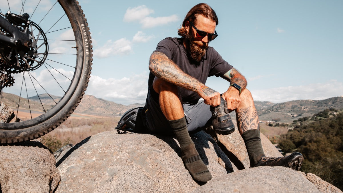 Mountain biker seated on rock wearing Element crew mountain bike socks