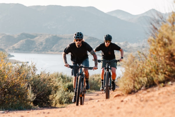 Two mountain bikers coming up the trail in the heat