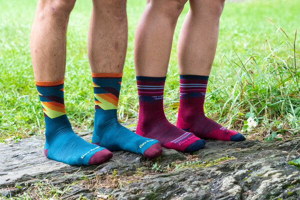 Two pairs of runner feet wearing the Bolt and Pacer running socks