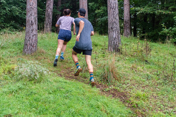 Trail runners headed up a grassy hill in hot weather