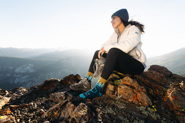 Hiker on summit on a cold day wearing warm merino wool socks