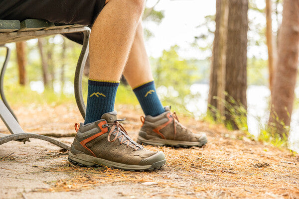 Feet wearing hiking boots and the men's hiker micro crew socks in blue