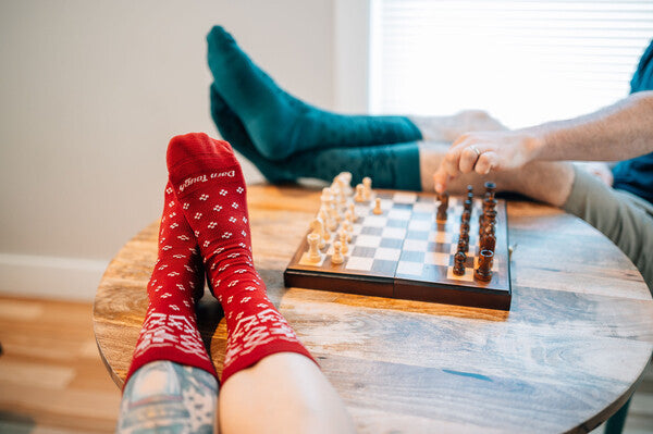 Two pairs of sock-clad feet up on the able wearing matching, quite handsome socks