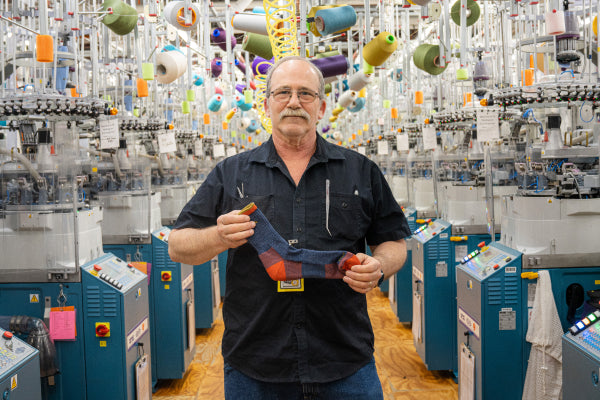 Jim at the Mill holding up the Hiker Micro Crew socks in denim blue