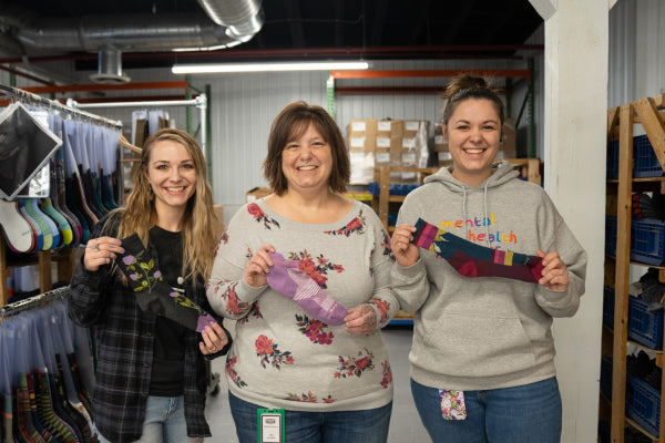 Myrissa and Mykayla with their mom Melissa, each holding a different sock they though mom would love