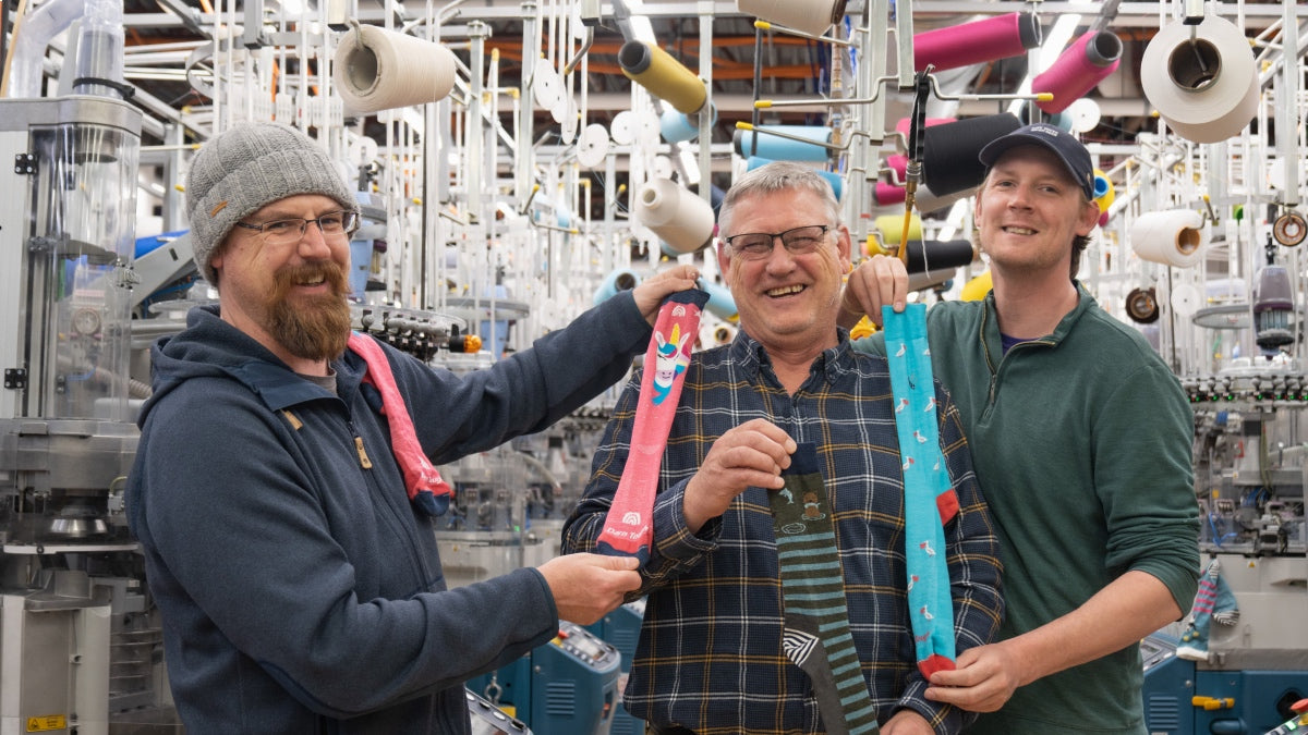 Two sons and their dad at Darn Tough mill, showing Father's Day gift ideas