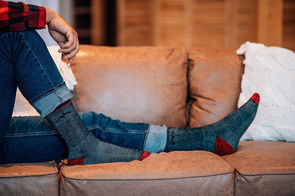 Person with feet up on couch, relaxing and staying cozy in darn tough hiking socks