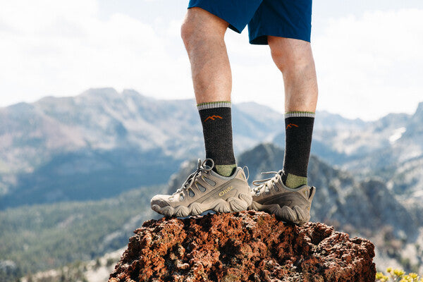 Hiker dramatically posing on summit wearing the men's hiker boot socks