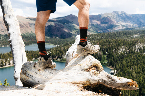Pair of feet standing on a high summit wearing darn tough socks