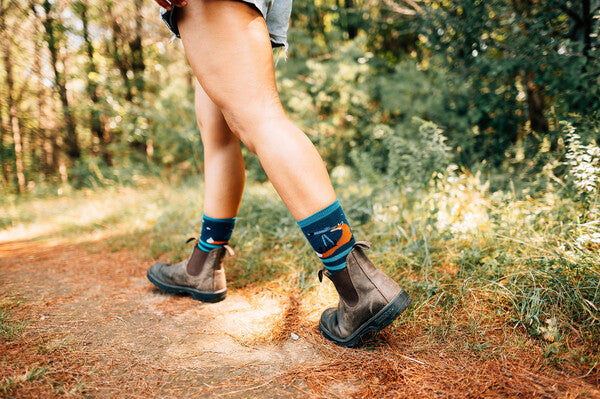 Person wearing darn tough socks with foxes on them, walking forward