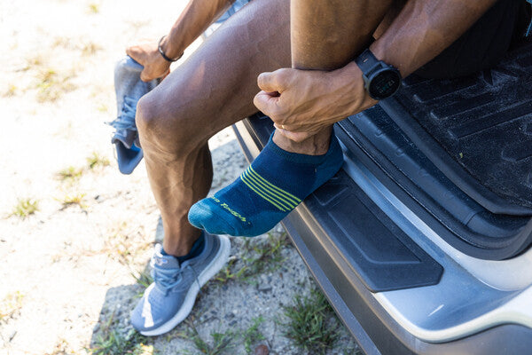 Closeup of feet wearing blue merino wool socks for running on hot day