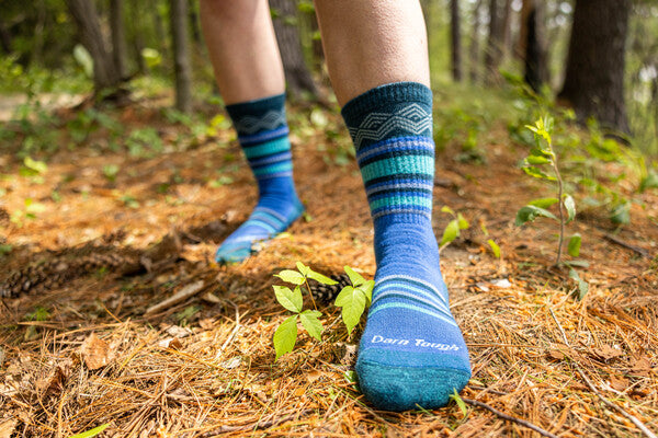 Person wearing blue merino wool socks from Darn Tough, showing off their stink-free feet