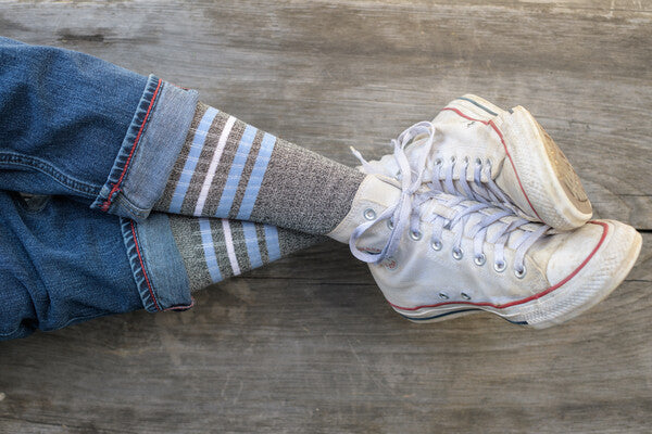 Crossed feet wearing converse and soft merino wool socks