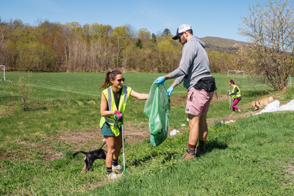 Two Darn Tough employees picking up trash and litter