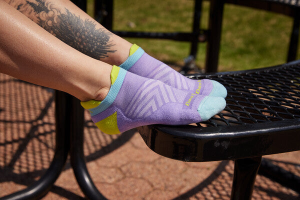 Feet wearing purple socks that have contoured sock cushioning