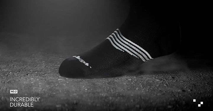 image of foot with black sock on stepping onto a dark, semi-rough surface with the words "incredibly durable" showing.