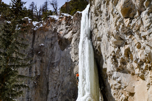 Ice climber headed up frozen waterfall in spring