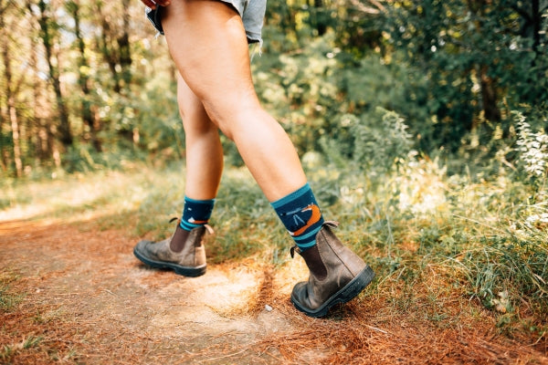 Woman walking on a trail in Blundstones and Darn Tough Animal Haus Socks
