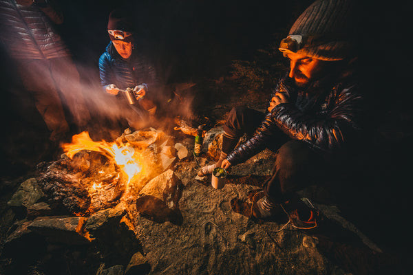 Hikers camped around a fire to stay warm in cold weather