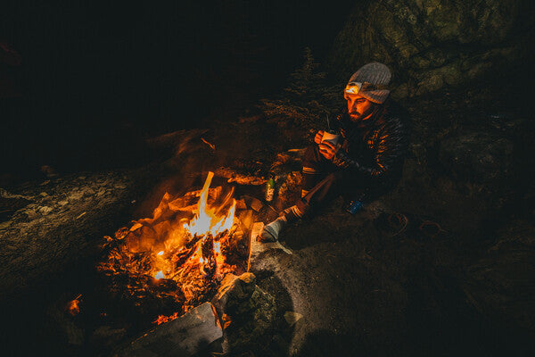 Man seated by fire wearing darn tough wools socks