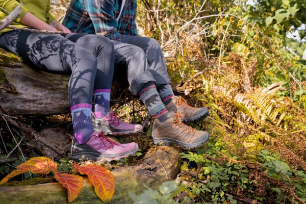 Two people sitting on a rock in Darn Tough Bear Socks