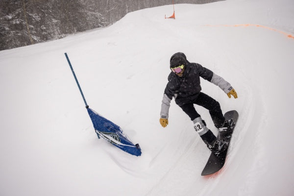 Snowboarder racing down the banked slalom