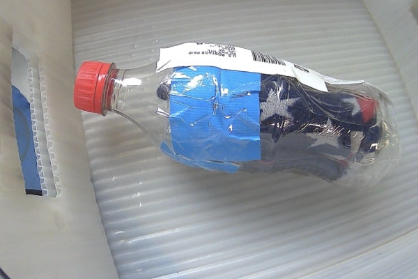 A plastic coca-cola bottle with a pair of Darn Tough socks squished inside
