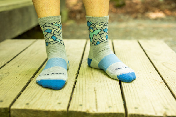 Model standing on a wooden porch outside in the Darn Tough Zuni Coolmax Socks