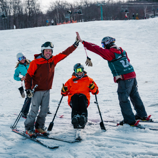 Two skiers giving each other a big high five