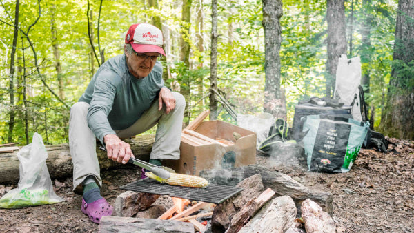 Jeff roasting corn over a campfire