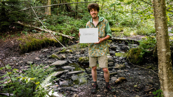 Seamonkey standing on the Appalachian  trail with a sign of his trail name