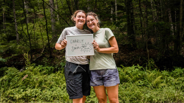 Twins Gnarly and Sarah holding a sign with their names and the words "best friends"