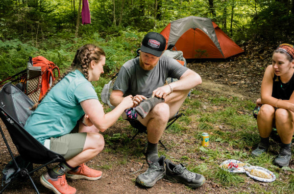 Darn Tough volunteer pointing at a thru hiker's socks, explaining how it works