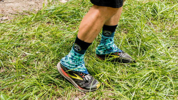 Pair of thru hiker feet wearing the ATC micro crew hiking socks with gaiters