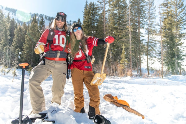 Two SAFE AS instructors out on the snow with snow shovels in hand