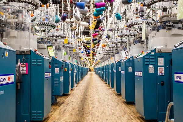 A row of knitting machines in Darn Tough's Mill