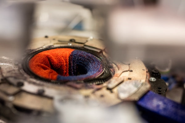 Close up of sock being knit on Darn Tough knitting machine