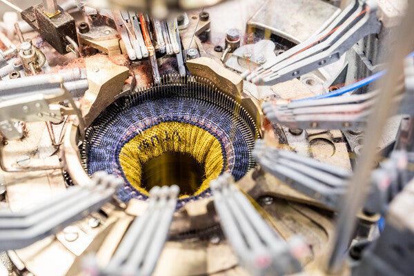 Closeup of sock being knit on Darn Tough knitting machines