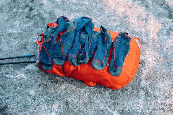 A bunch of darn tough hiking socks piled on a rock