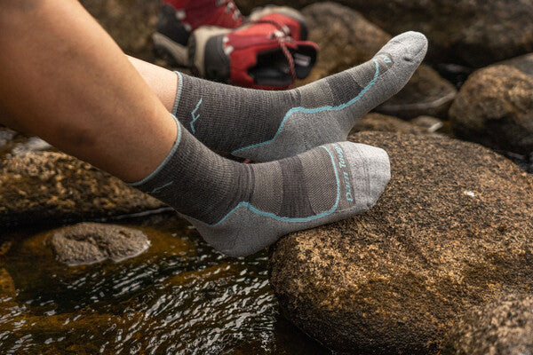 Feet wearing the Light Hiker micro crew hiking socks by a stream