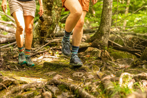 Couple coming down the trail wearing matching Decade Stripe hiking socks