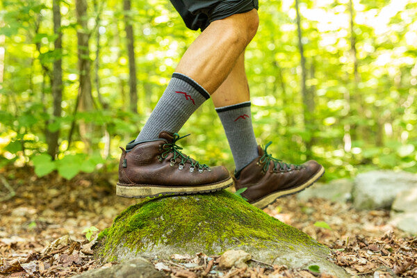 Hiker feet in leather boots and gray synthetic socks