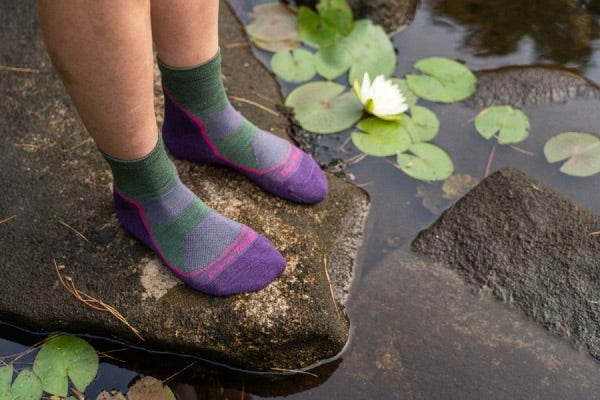 Woman by water wearing darn tough light hiker merino wool socks