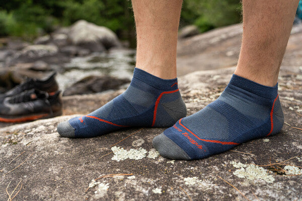 Closeup of feet wearing the men's light hiker no show socks in blue