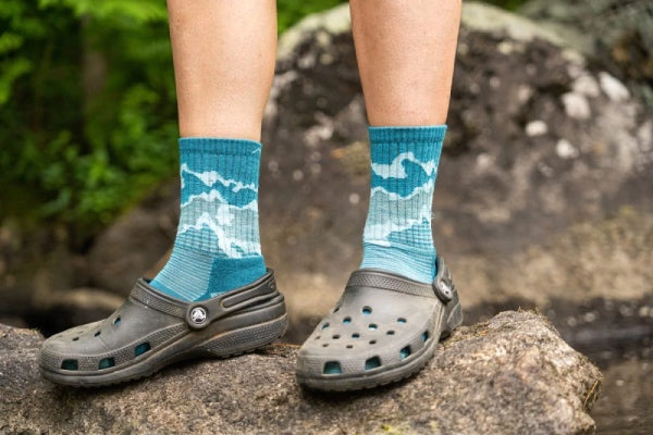 Person wearing darn tough hiking socks with crocs