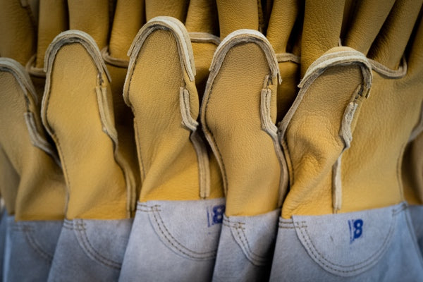 A row of gloves with the seams freshly sewn on the outside